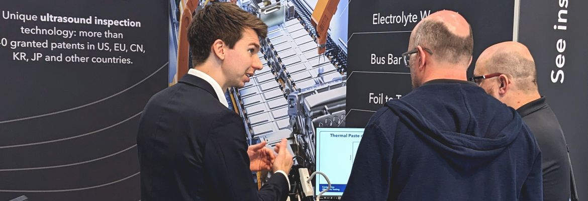 Visitors at the XARION booth during the Control trade show, with a wall listing the company's global patents