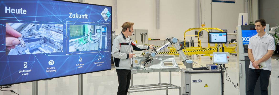 XARION team members presenting the automated spot-weld inspection system to Porsche next to a robotic test setup