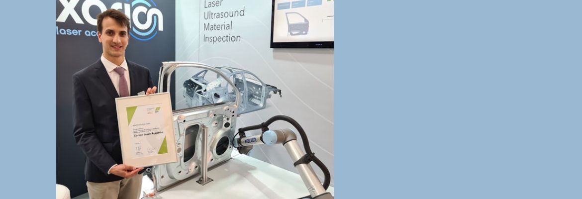 Ein XARION-Vertreter h&auml;lt die Innovationspreis-Troph&auml;e der Laser World of Photonics am Messestand des Unternehmens